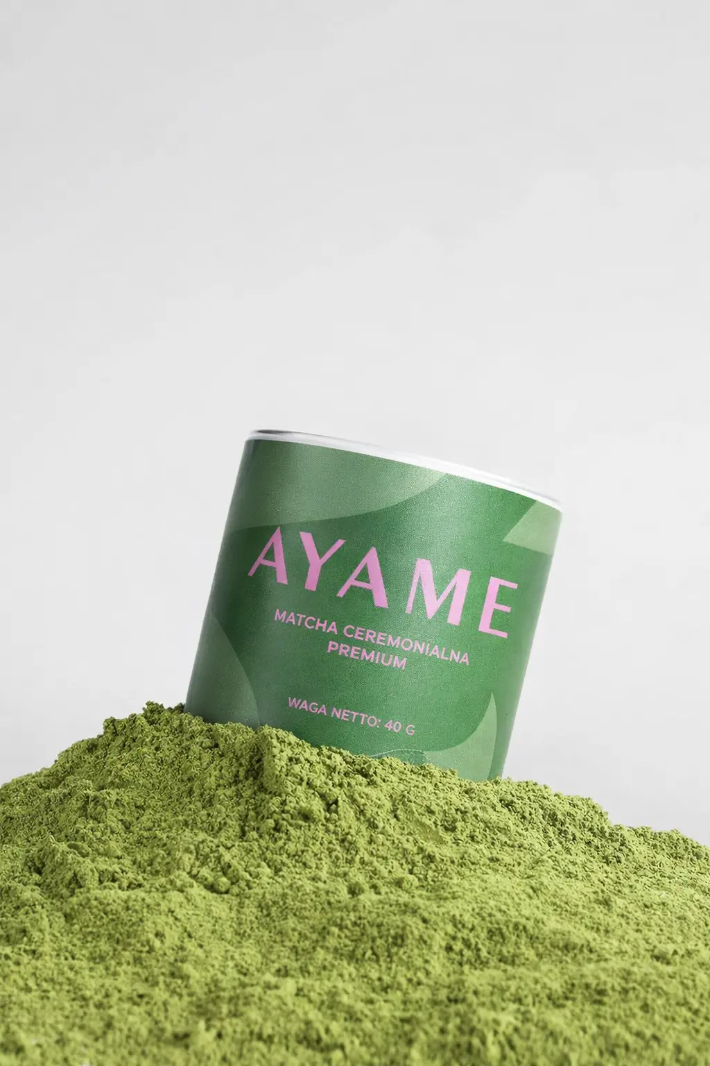 Puszka Ayame Matcha Ceremonialna Premium zanurzona w kopcu intensywnie zielonej herbaty z Uji.